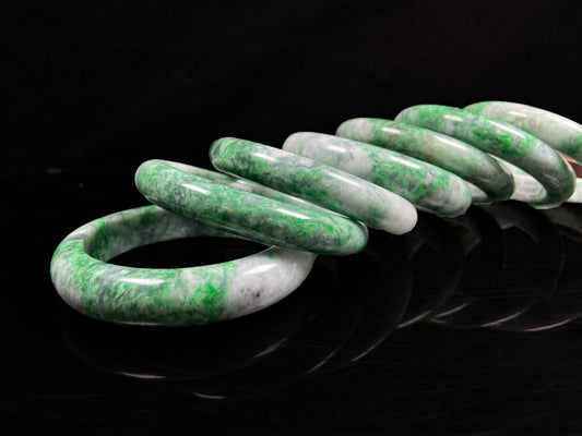 A group of white-base green-pattern jadeite bangles.