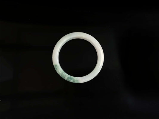 A snow white with green splash jadeite bangle.