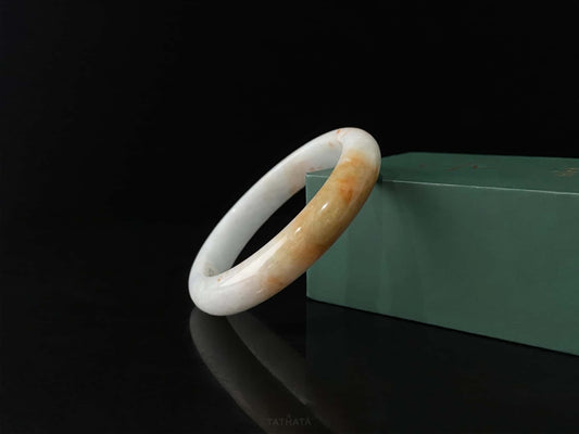 A amber dawn vein jadeite bangle.