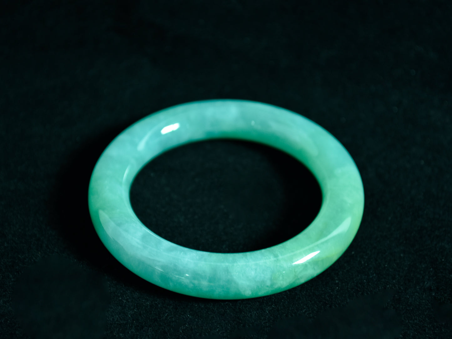 Green jade bracelet on a black background