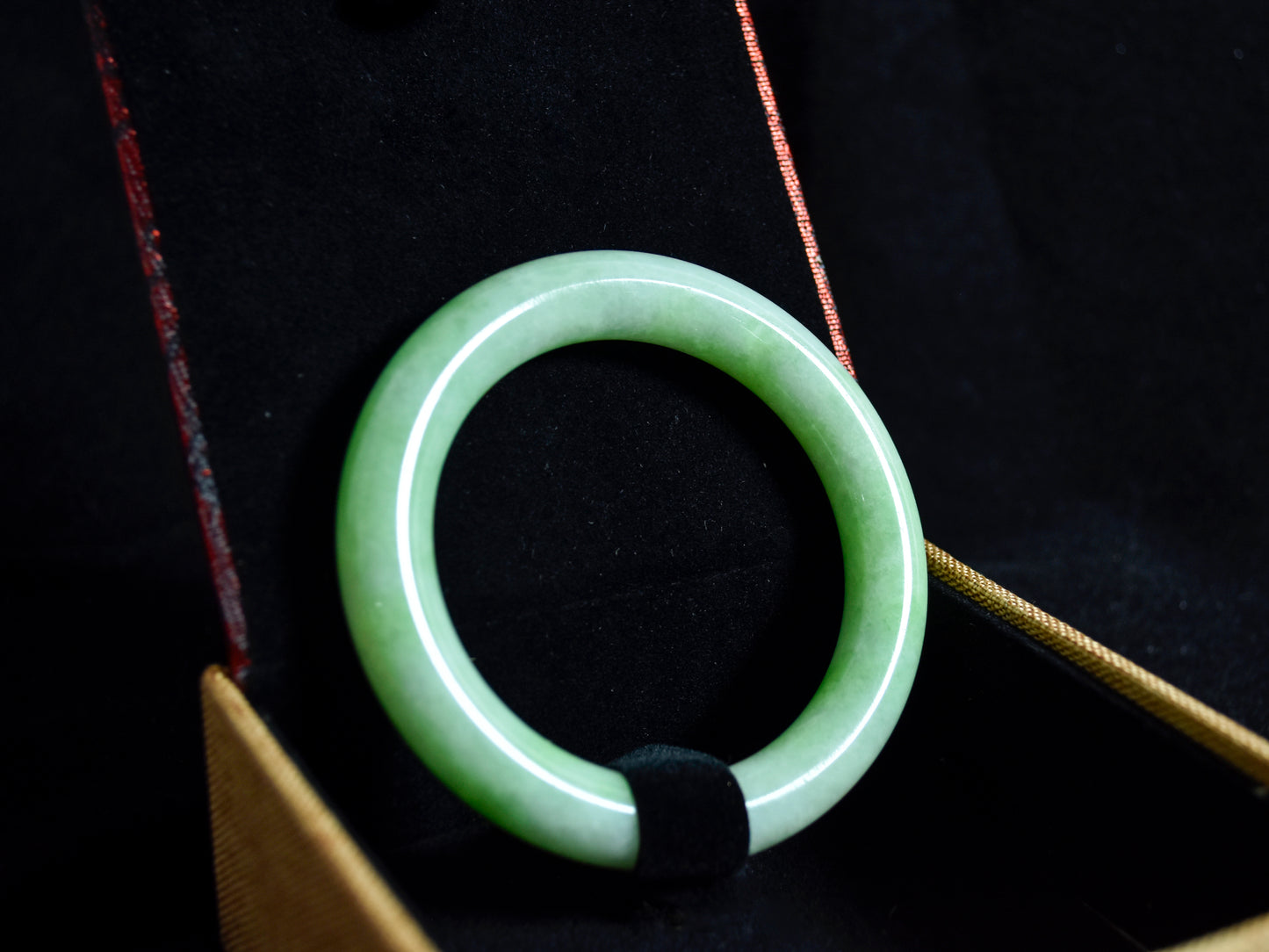 Green jade ring on a dark background