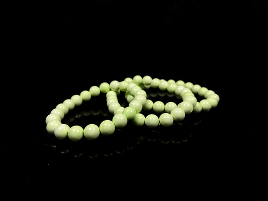 A turquoise green smooth bead ceramic beaded bracelet.