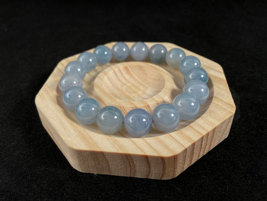 A translucent icy jade bead strand in sky blue tones with floating blue floral inclusions.