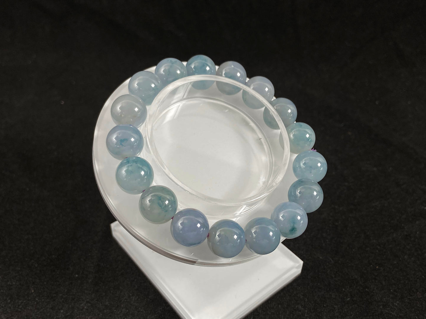 A translucent icy jade bead strand in sky blue tones with floating blue floral inclusions.