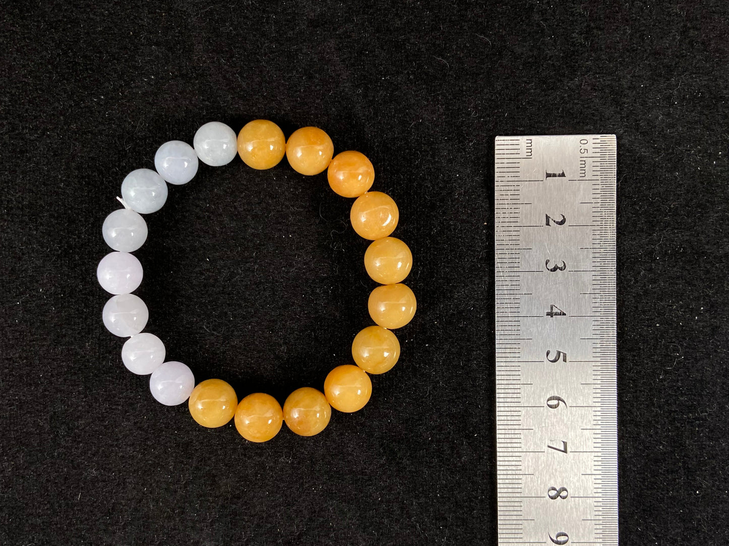 A jade strand with yellow beads and white beads softly blended with pink, green, and gray.