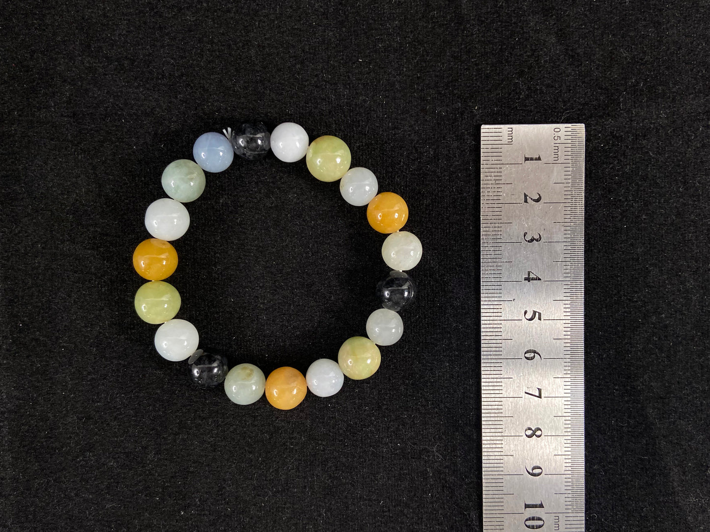 A jade bead strand in earthy brown, pure white, classic black, and ethereal blue-white.