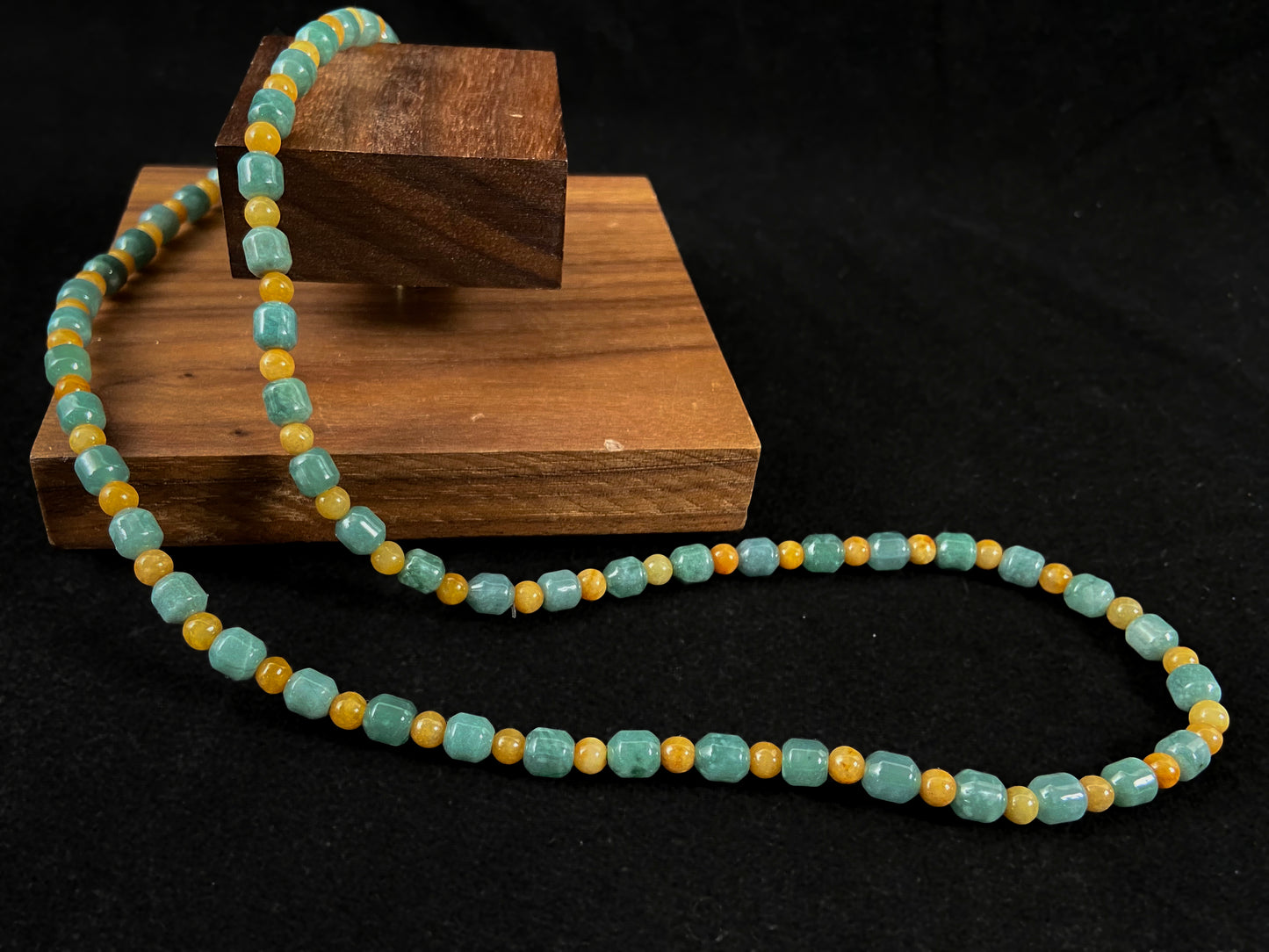 A jade strand combining cyan cylinder beads and yellow round beads.