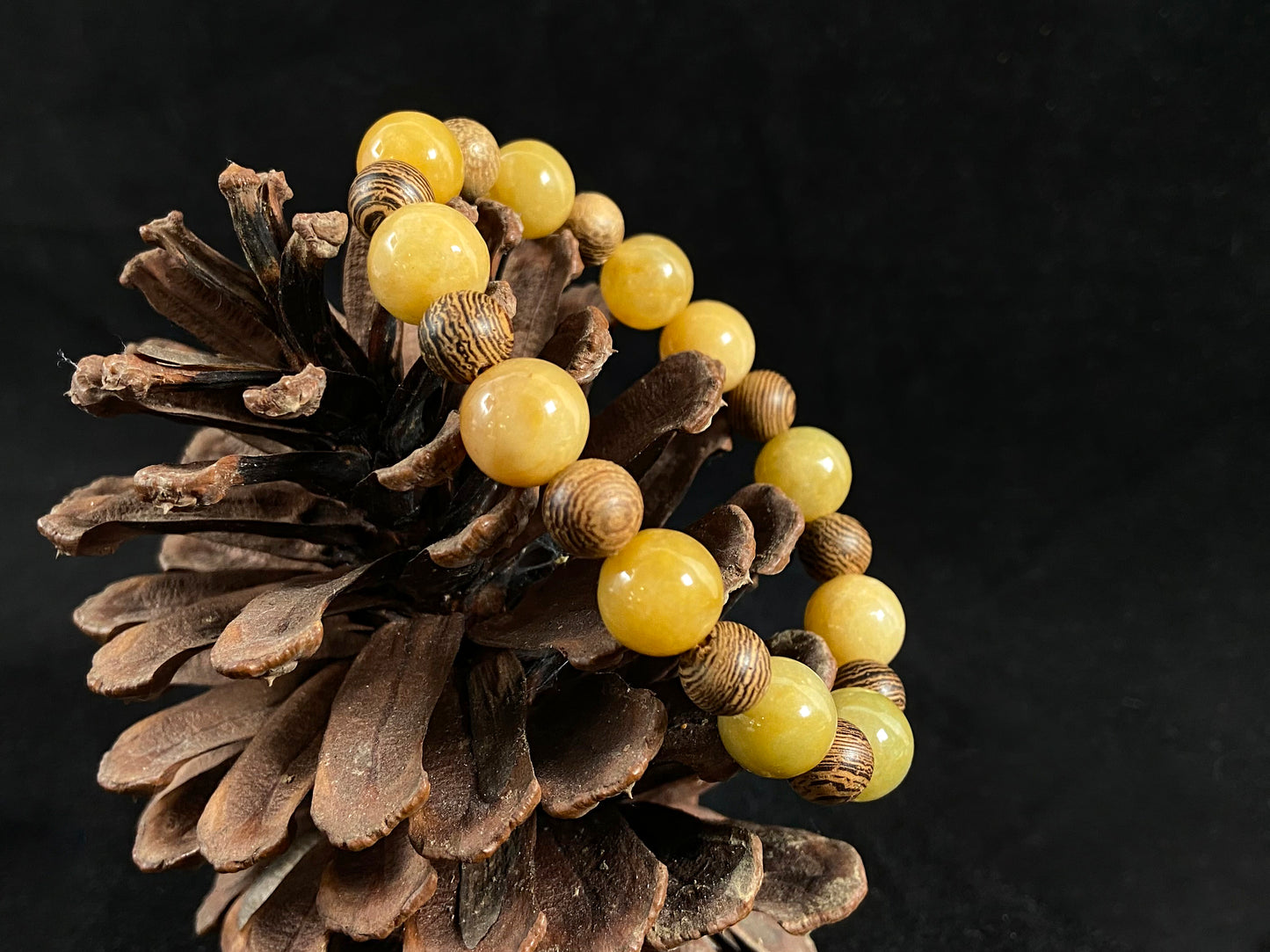 A jade and sandalwood bead strand featuring alternating yellow jade and wooden beads.