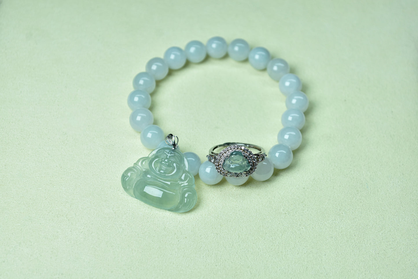 Pearl bracelet with jade pendant and ring on a light green background
