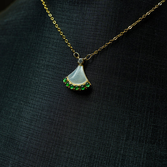 Necklace with a pendant featuring a green gemstone on a black background