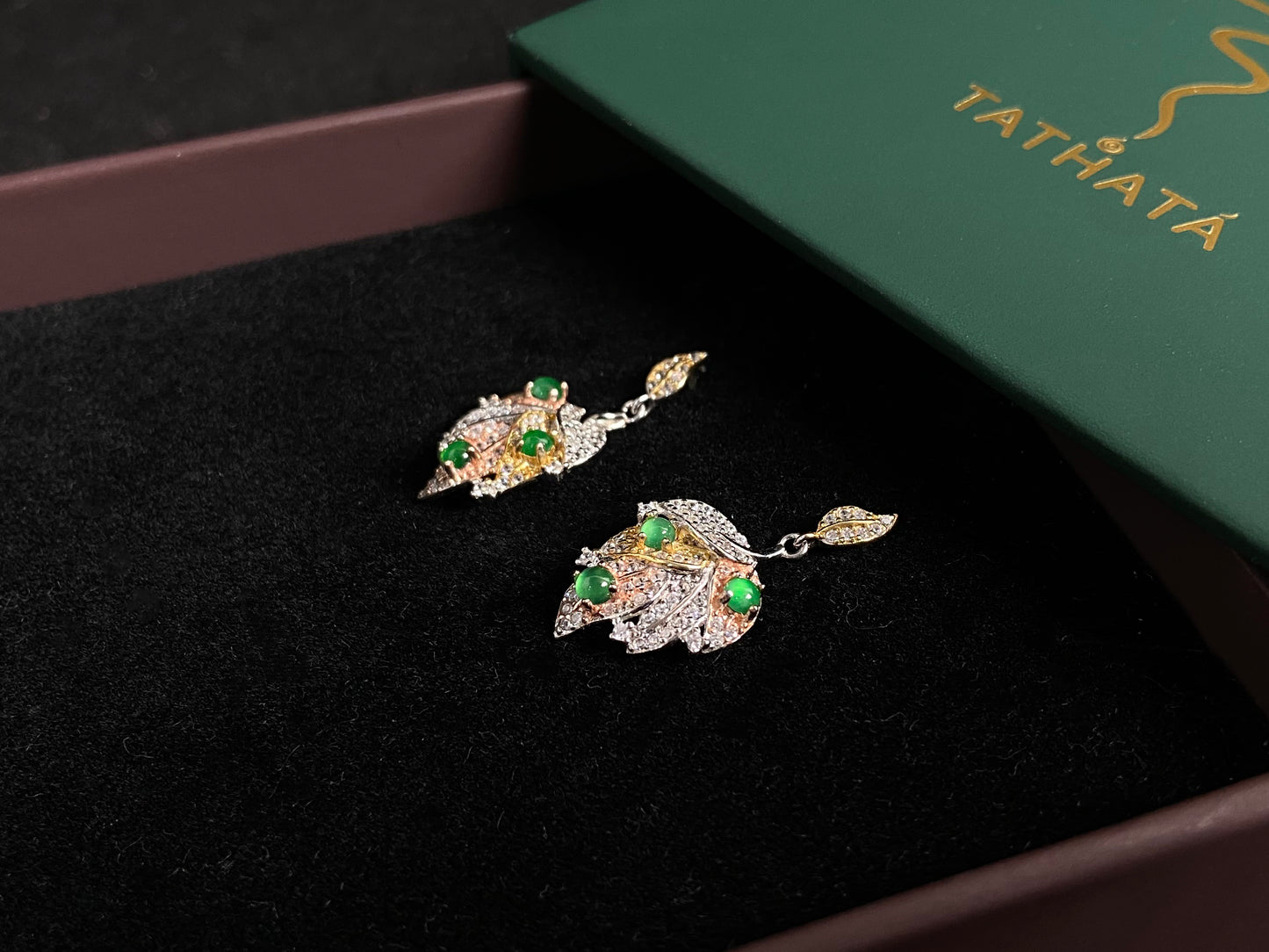 A pair of earrings featuring two 925 silver leaves, each adorned with three green jade beads, available in gold plated or natural silver finish.