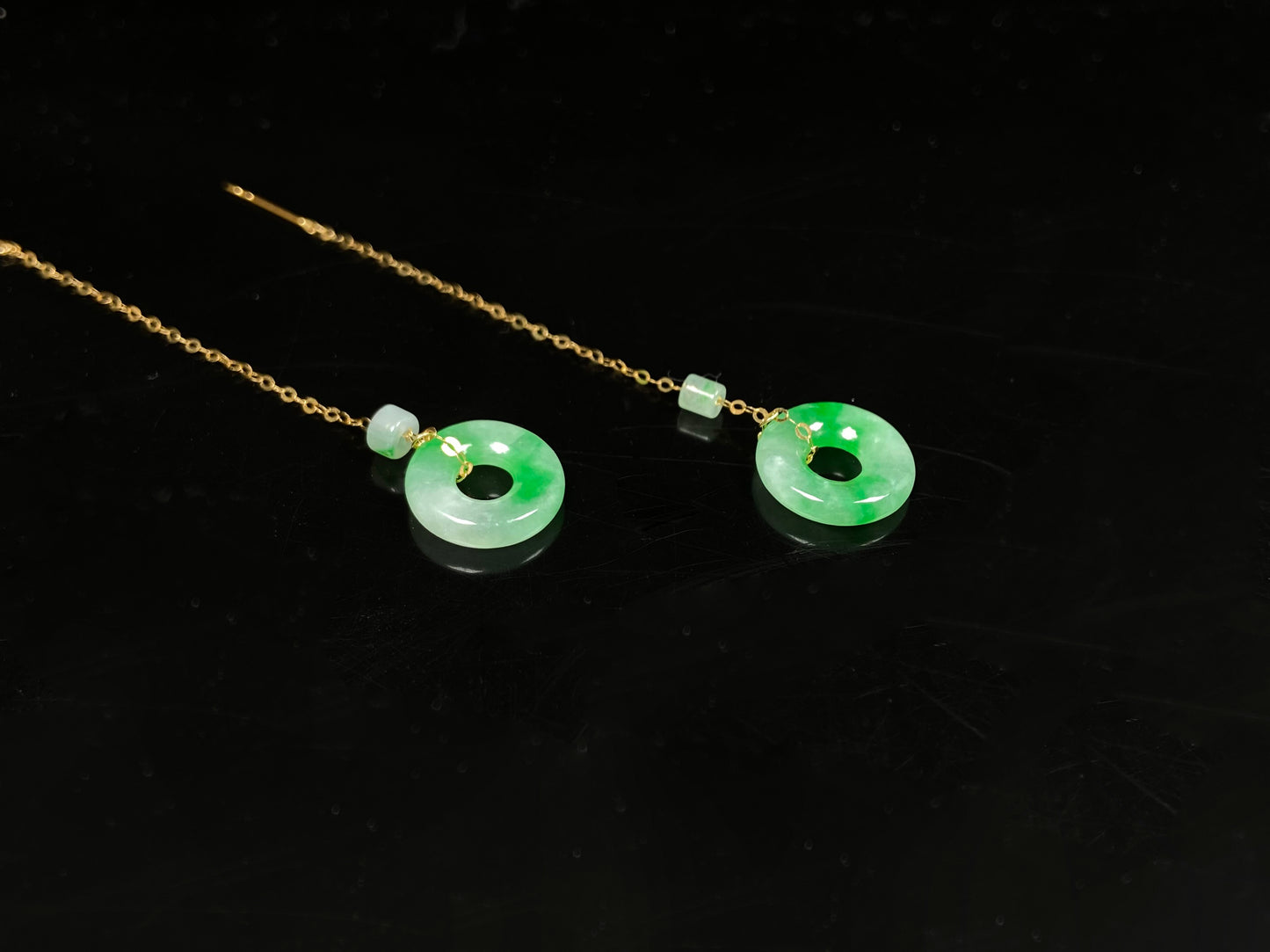A green dew donut and cylinder jadeite earring.
