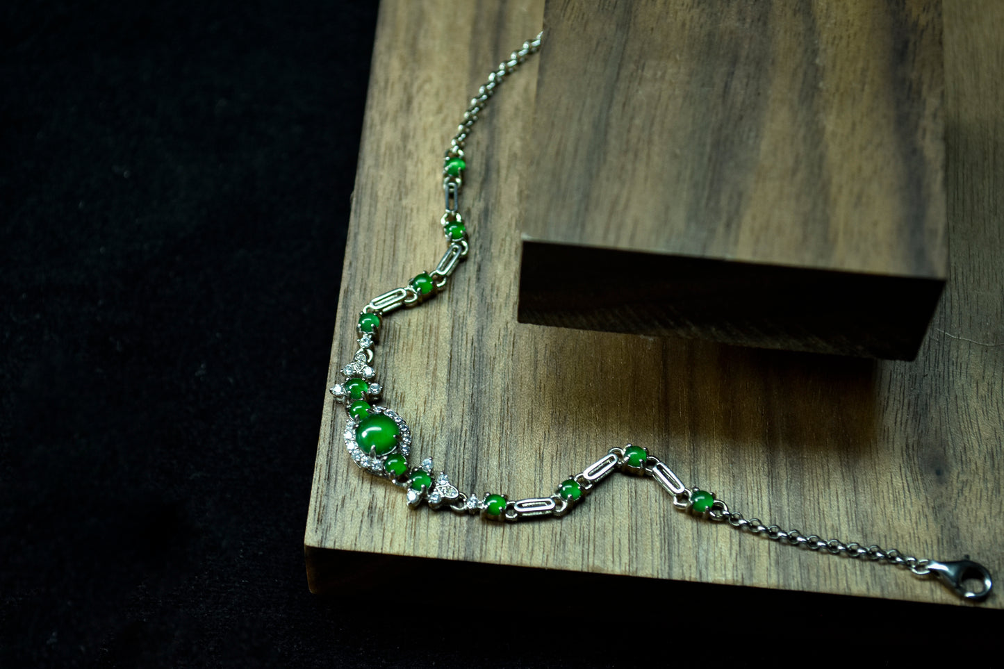 Green beaded bracelet on a wooden block with a dark background