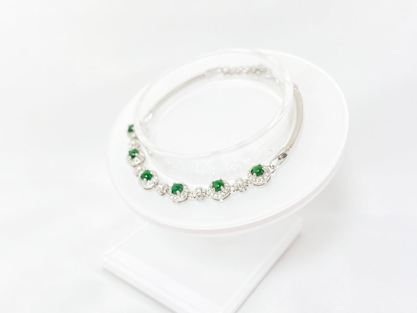 A bracelet featuring six vibrant green jade cabochons set in copper frames.