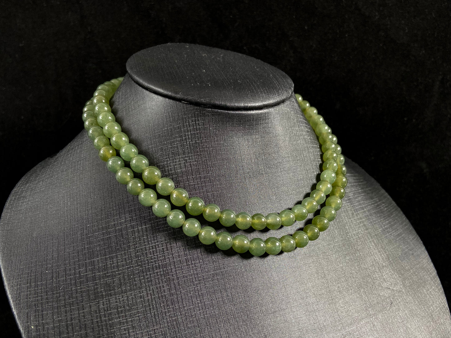A jade bead strand composed of translucent dark green beads.