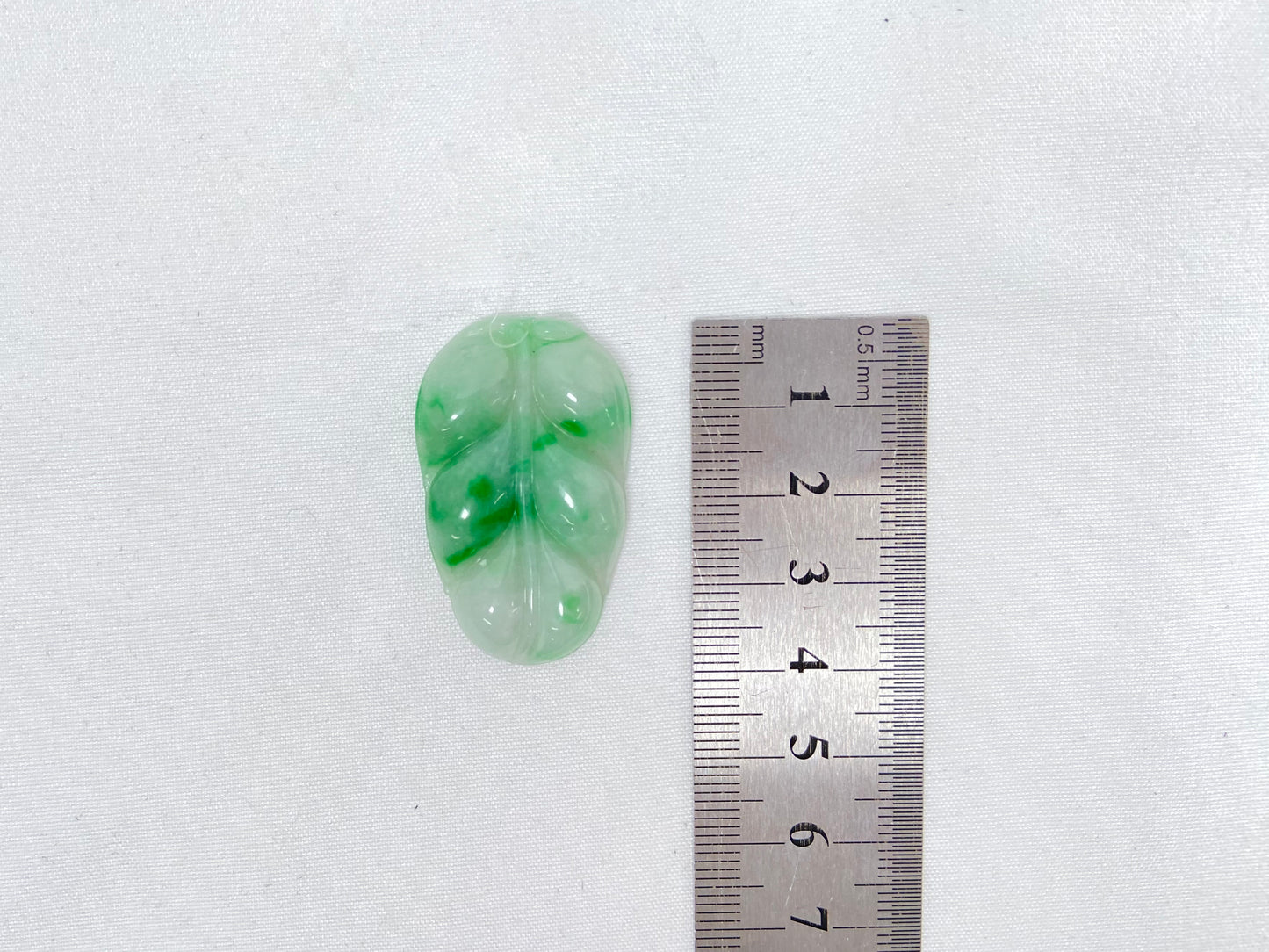 A jadeite stone with a milky white base and vibrant green patches.