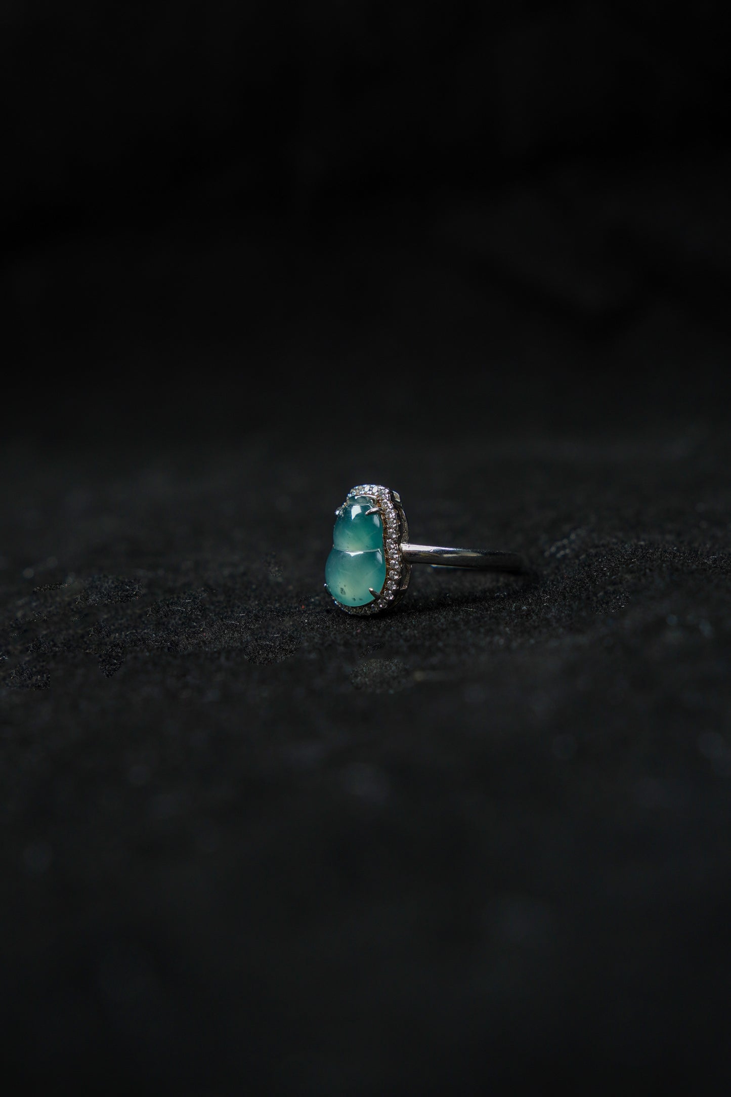 Silver ring with a turquoise stone on a black textured background