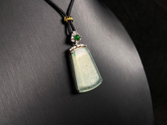 A clear light green "Wu Shi" plaque pendant, framed in 925 silver.