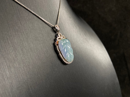 A leaf shaped jade pendant featuring translucent green blending into soft purple, elegantly framed in 925 silver.