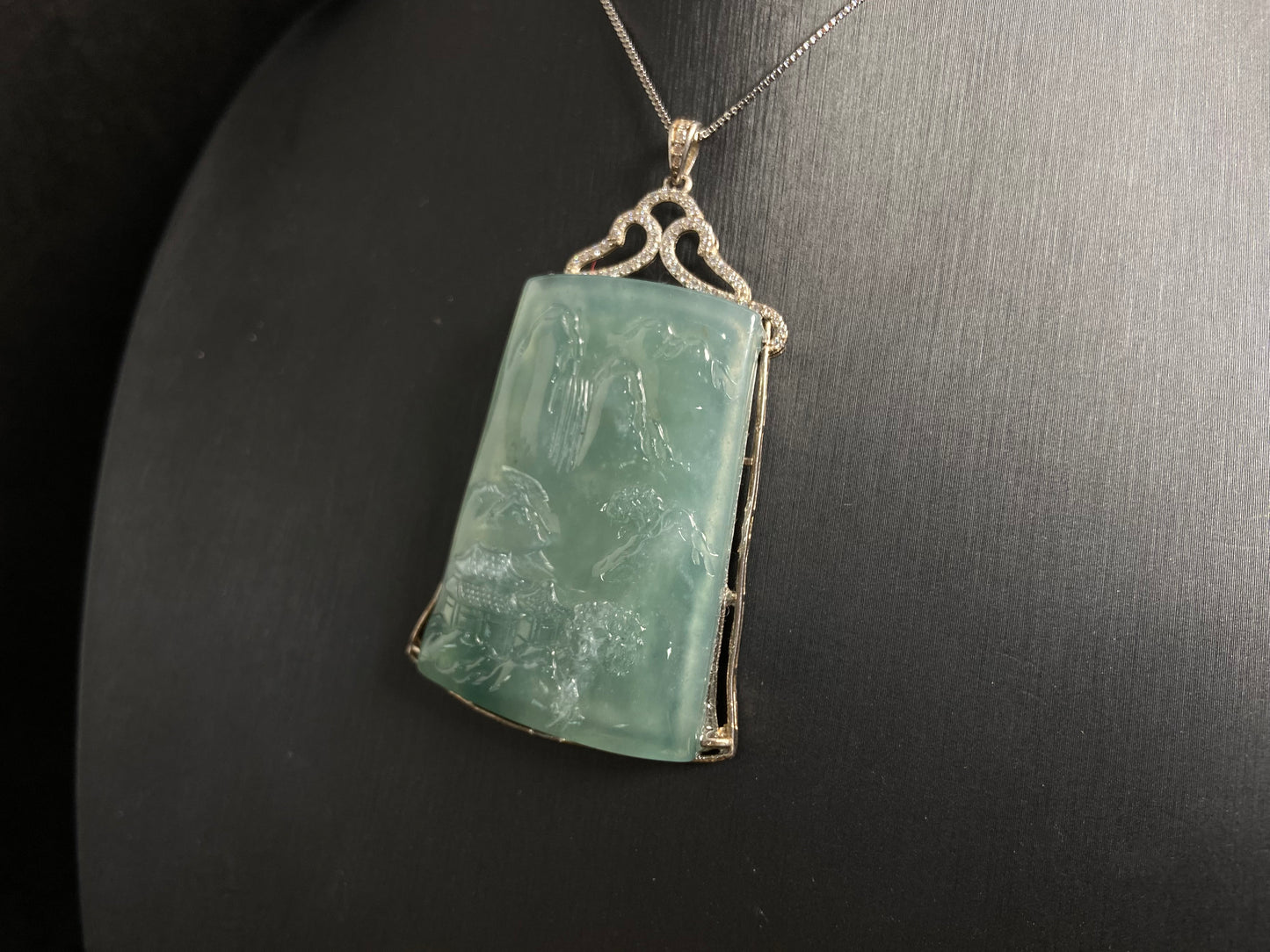 This jade pendant is a light green landscape plaque.