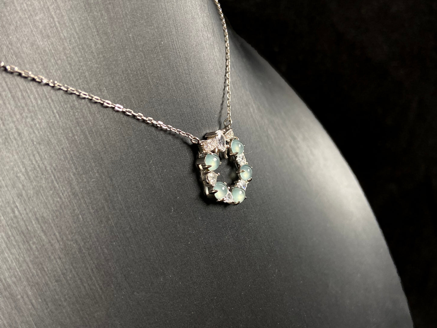 A pendant featuring five pale blue translucent jade beads, accented with diamonds and set in 925 silver.