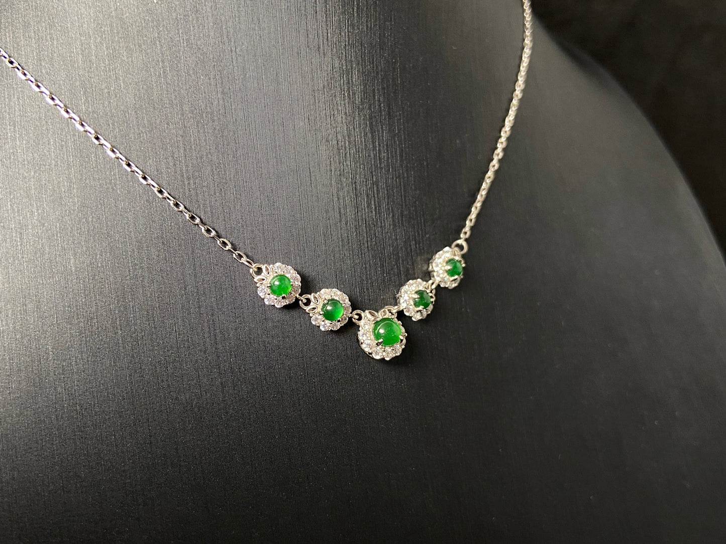 A jadeite pendant featuring five green beads exquisitely set in 925 silver.