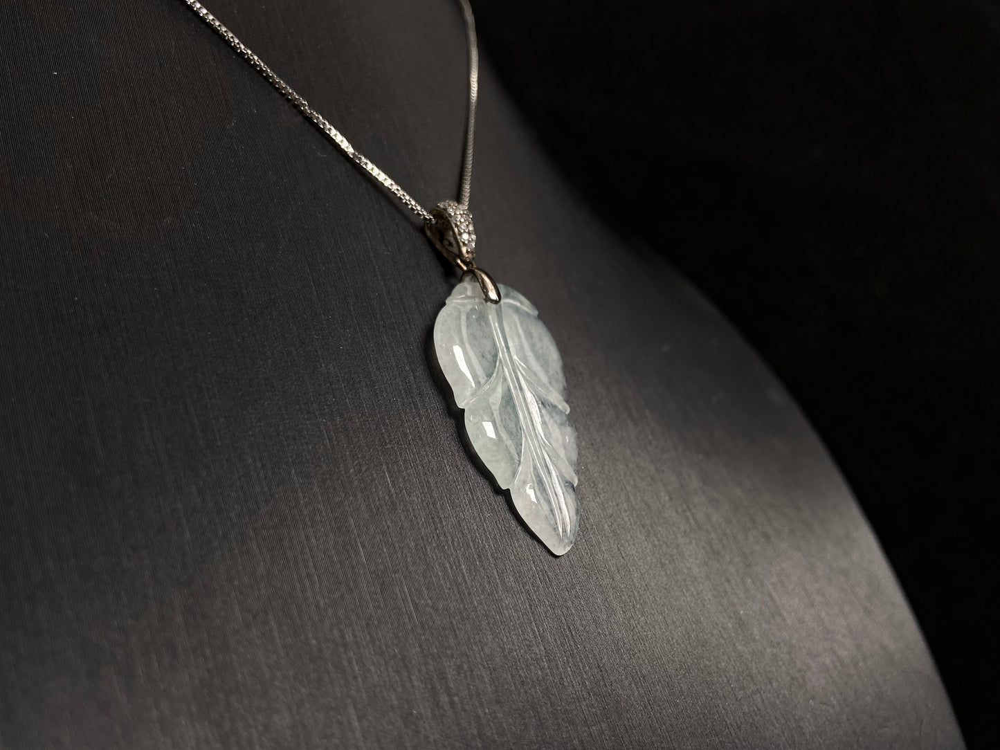 An icy jade leaf pendant, elegant and pure.