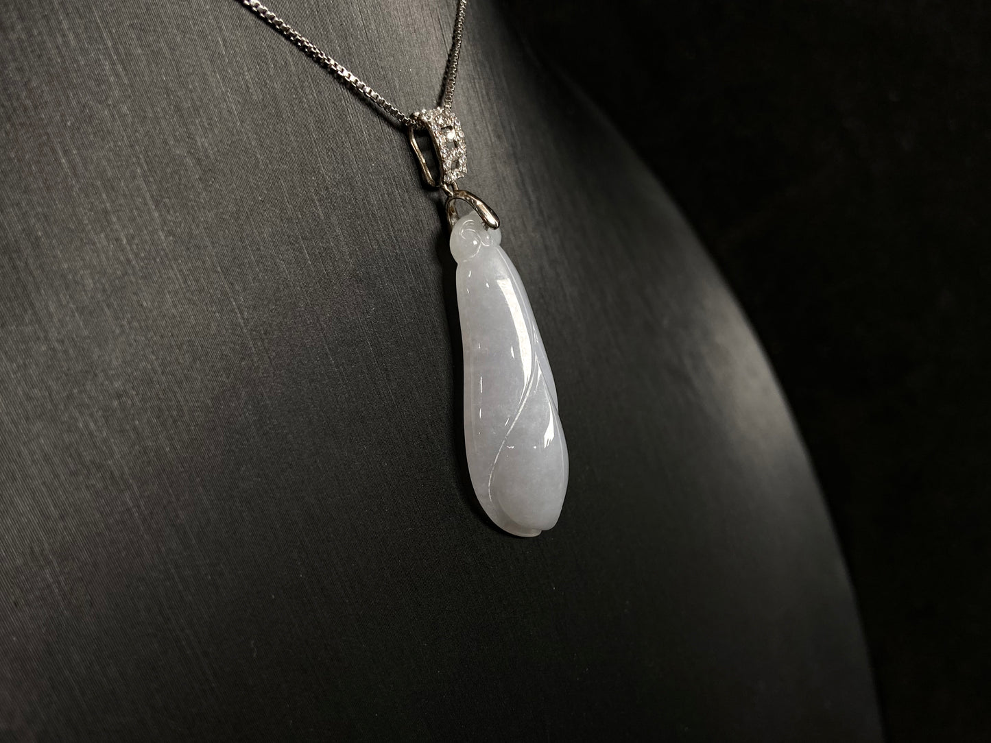 A milky white jade orchid blossom pendant, elegant and pure in its simplicity.