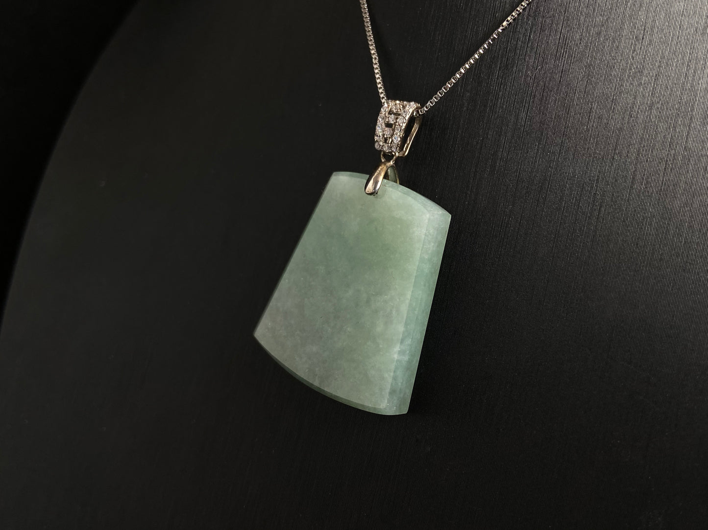 A pale greenish white jade plaque, perfectly plain and polished smooth.