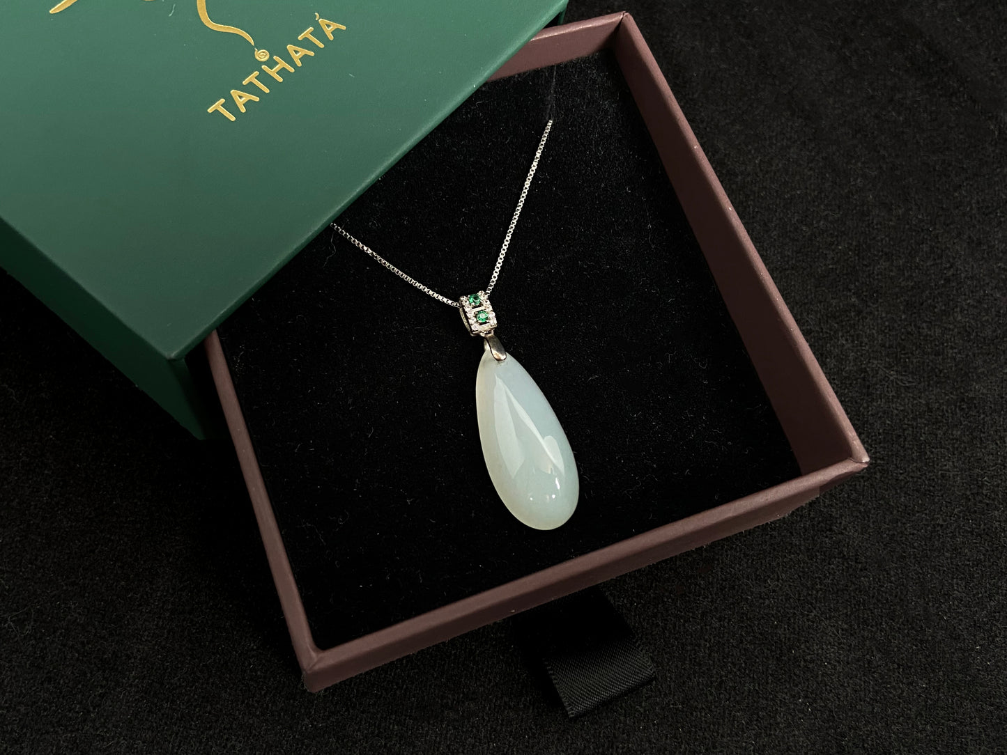 A translucent, milky white jade pendant crafted in a graceful teardrop shape.