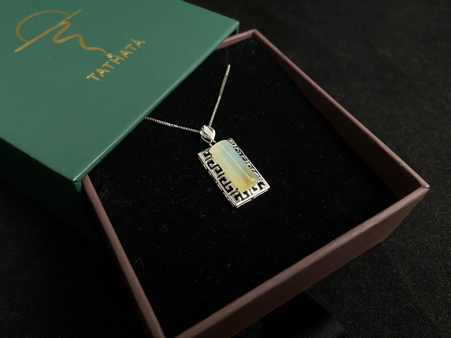 This unique jade pendant features a semi cylindrical column design with a subtle yellow accent floating at its base.