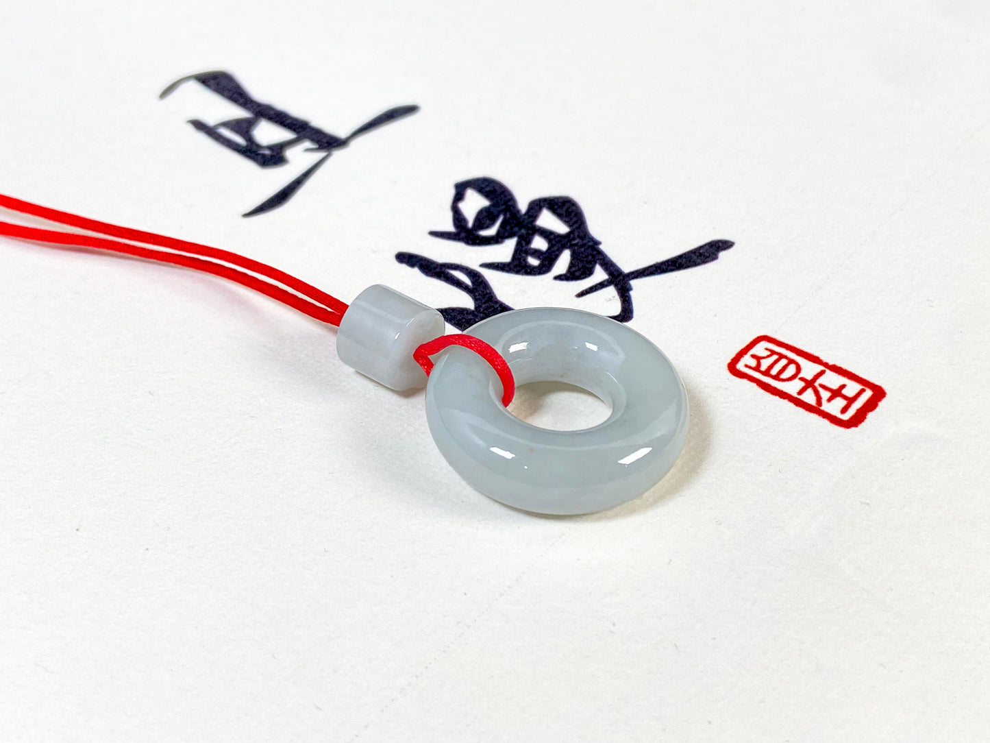 A creamy white jade pendant shaped as a peace ring.