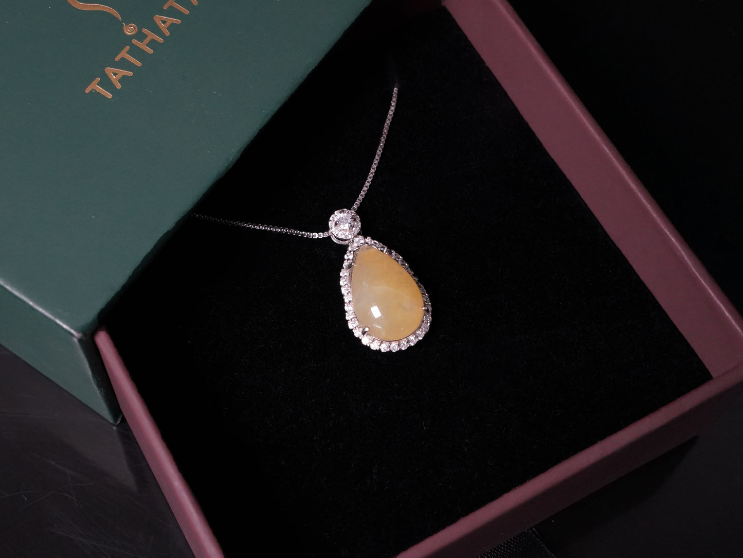 A pale yellow teardrop jadeite pendant.