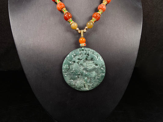 A deep green mountain scenery jadeite pendant.