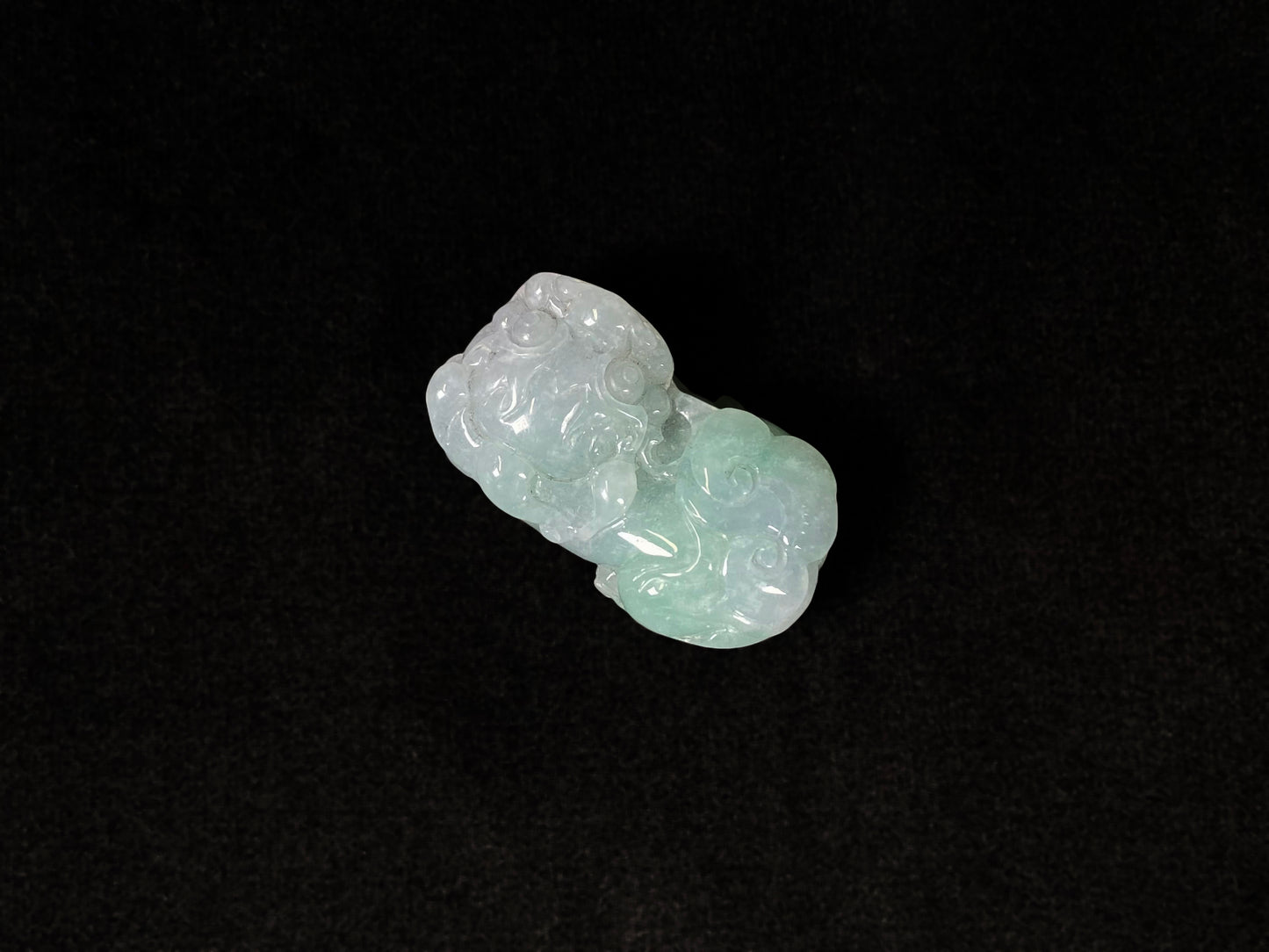 A Pi Xiu jadeite carving with a light green lower body and creamy white head.