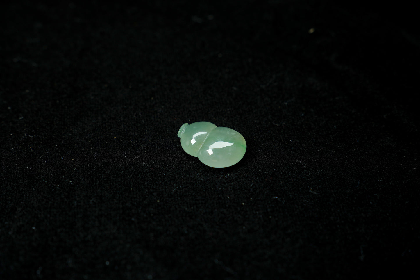 Two green gemstones on a black background