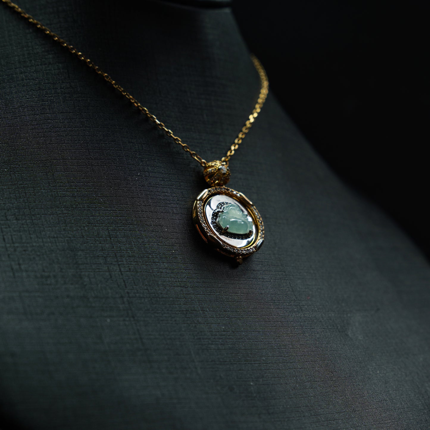 Necklace with a pendant featuring a green gemstone on a dark fabric background