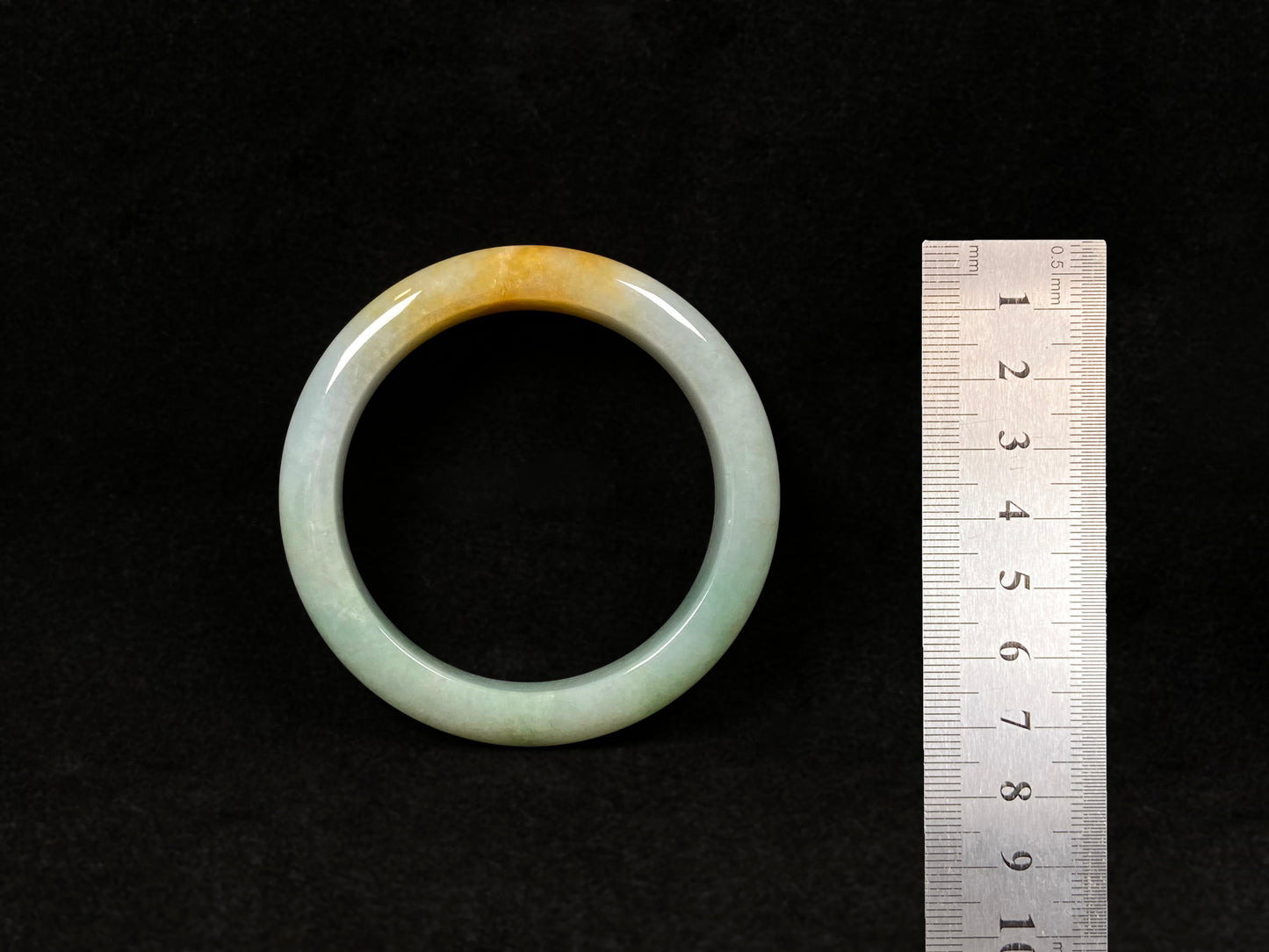 A light green jadeite bangle with a bold splash of gold.