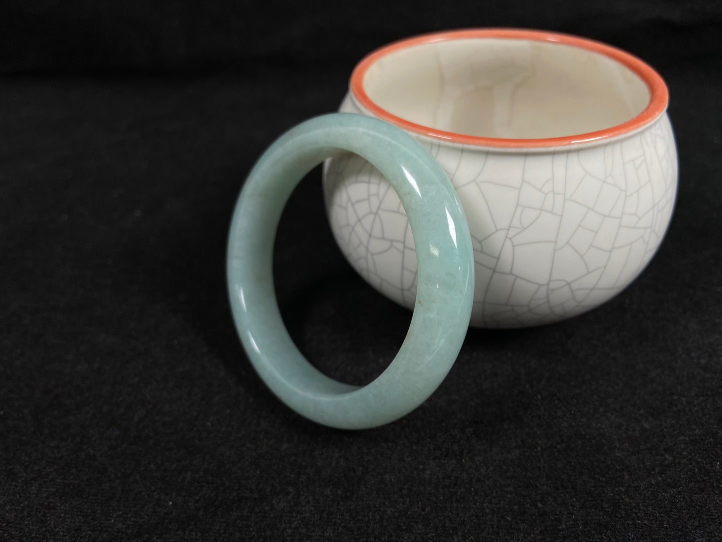 A light green jadeite bangle with gold speckles.