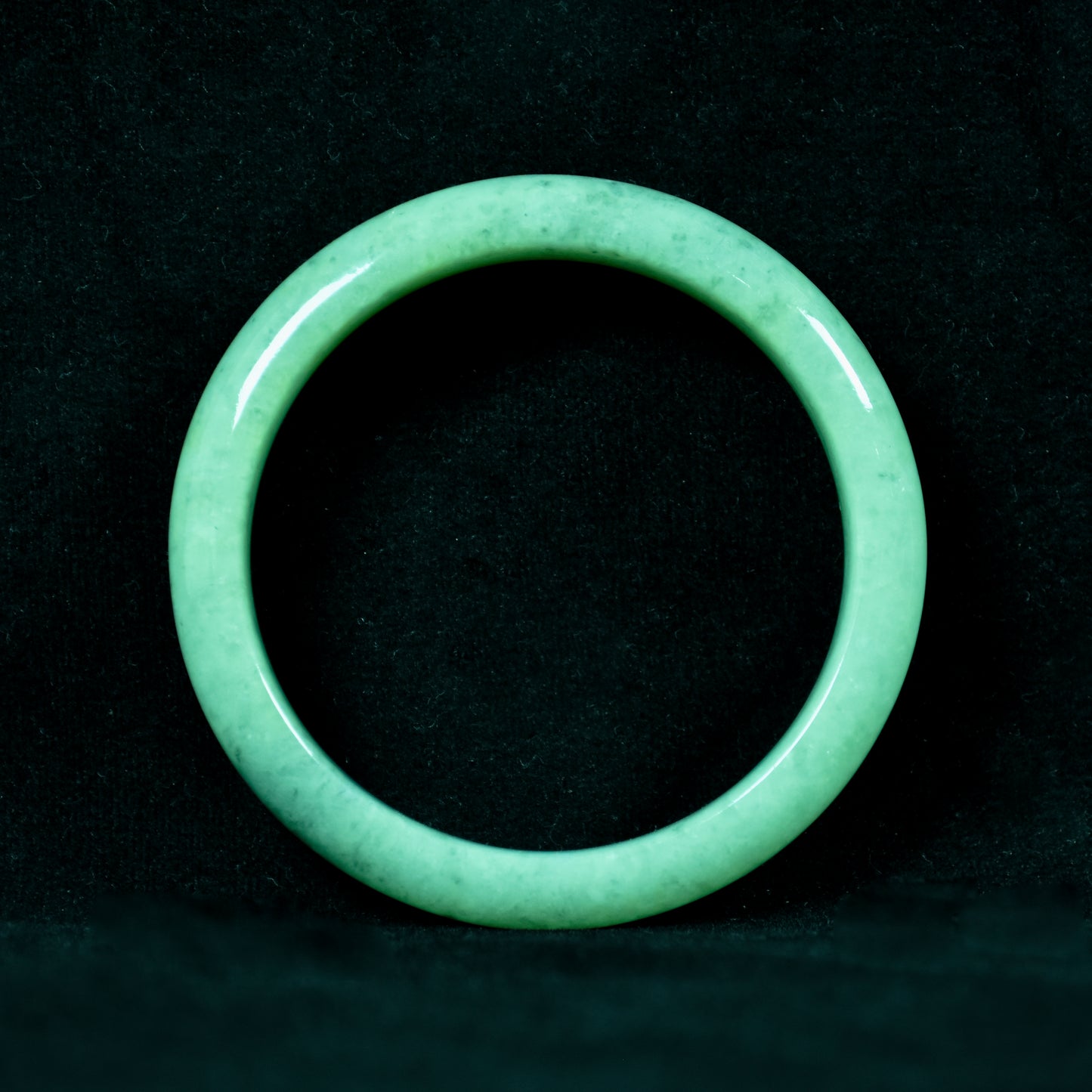 Green jade ring on a black background