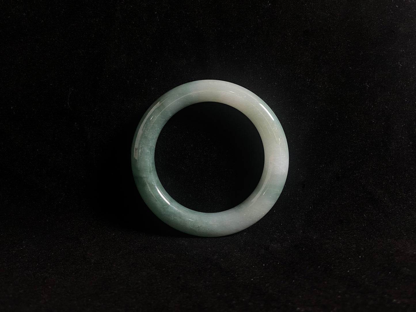 Green jade ring on a black background