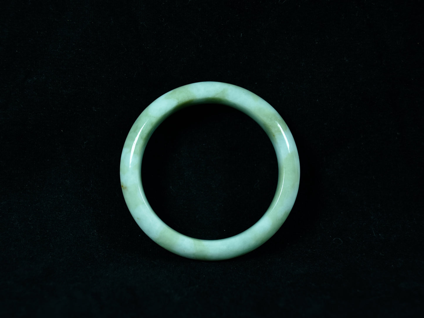 Green jade ring on a black background