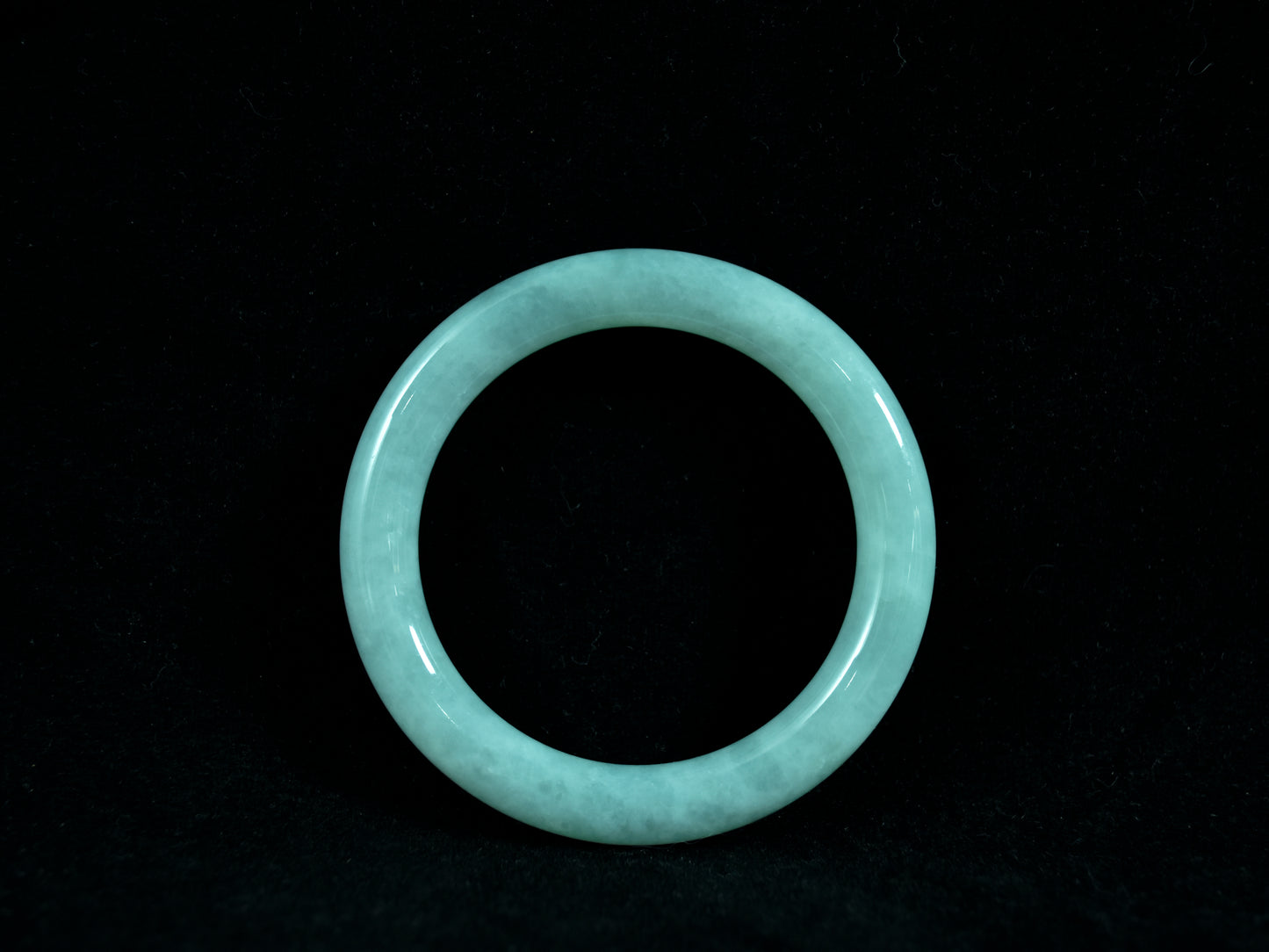 Light blue jade bracelet on a black background
