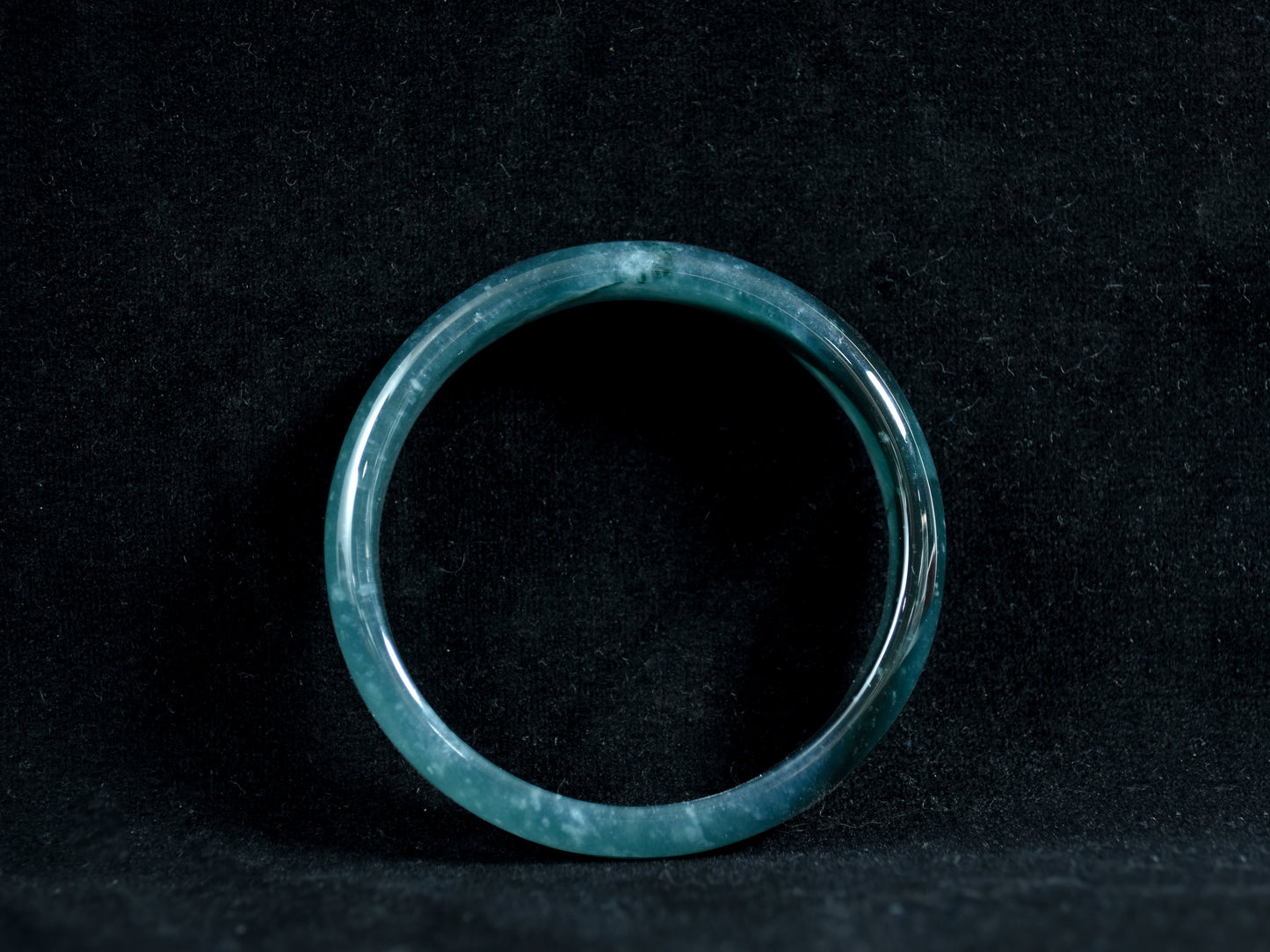 Green jade ring on a black background