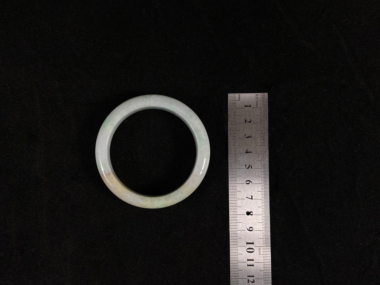 A white-green jade peace bangle delicately sprinkled with golden dust.