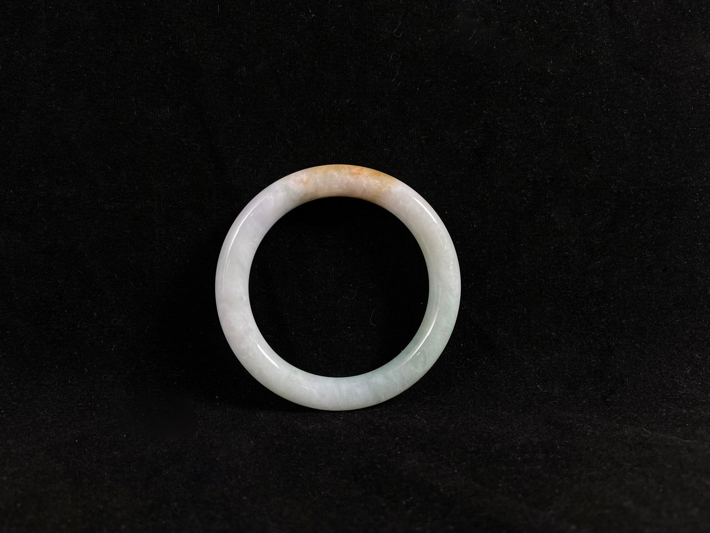 White jade ring jadeite bangle on a black background