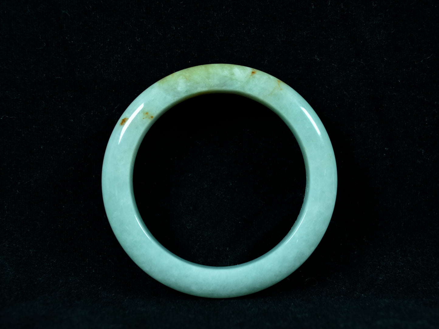 Green jade ring on a black background