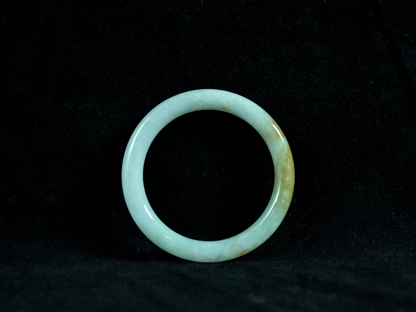 Green jade ring on a black background