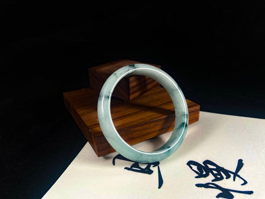 Silver ring on a wooden stand with a dark background