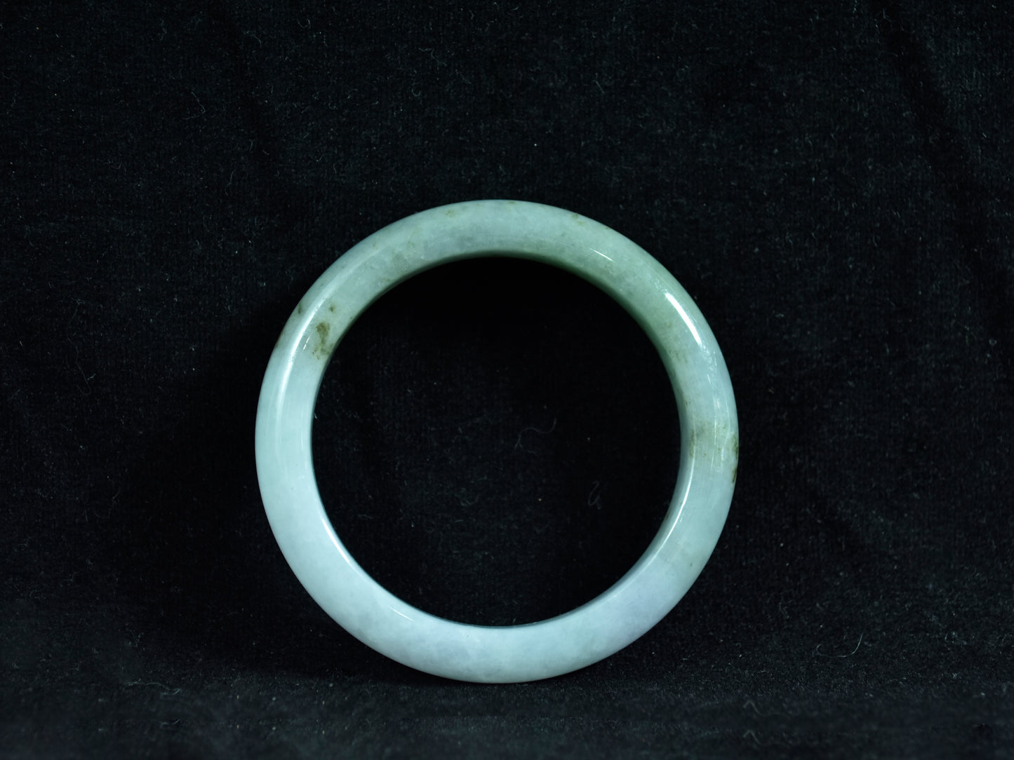 Green jade ring on a black background